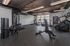 Modern apartment gym with state-of-the-art fitness equipment, including treadmills, a StairMaster, and a weight machine, offering a bright and inviting workout space.