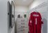 Chic closet area with a stylish mirror, drawer chest, and hanging sports jersey.