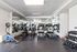 Modern fitness center with state-of-the-art treadmills, elliptical machines, and a comprehensive free weights section.