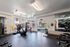 Bright and spacious apartment gym with modern fitness equipment and large windows offering natural light.