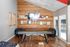 Chic recreational room showcasing a contemporary shuffleboard table, rustic wood-paneled wall with mounted TV, and cozy seating area, perfect for entertainment and relaxation.