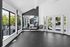 Bright fitness area with large windows, modern equipment, and sleek design offering a refreshing workout experience.