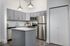 Modern kitchen design featuring sleek gray cabinets, stainless steel appliances, and elegant pendant lighting with a spacious countertop island.