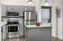 Modern kitchen with sleek gray cabinets, stainless steel appliances, and a granite island, complete with an in-unit washer and dryer for convenience.