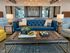 Chic living room with a luxurious navy blue sofa, stylish decor accents, and modern lighting, creating a warm and inviting atmosphere.