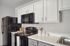 kitchen with black appliances and white cabinets