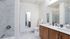 Bathroom with two sinks, toilet, and shower