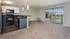Vacant living room, dining room, and kitchen with black appliances