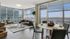 Furnished living room and dining room with wall to wall windows