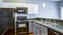 Kitchen with black appliances and white/grey cabinets