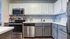 Kitchen with stainless steel appliances and grey and white cabinets