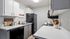 Kitchen with black appliances with grey and white cabinets