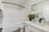 Arrive Santa Clarita Bathroom with White Cabinetry and Black Appliances