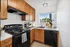 Alturas Vose Townhomes Kitchen with Wooden Cabinets and Black Applicanes
