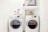 Modern laundry area featuring a sleek washer and dryer with storage shelf.