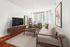 Modern living room with stylish furniture, abstract wall art, and large window enhancing natural light.