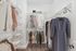 Stylish and organized walk-in closet with neatly arranged clothing and ample shelving.