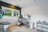 Bright pet washing station with sleek stainless-steel tub and modern white tile walls.