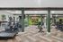 Spacious gym featuring cardio machines, weight racks, and a vibrant mural backdrop.