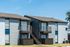 Elegant two-story apartment building with spacious balconies and modern design.