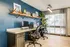 Contemporary home office with dual workstations, chic shelving, and abundant natural light.