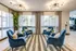 Sophisticated lounge with plush blue chairs, vibrant lighting, and large windows creating a warm, inviting space.