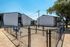 Bright and spacious apartment exteriors with fenced play area under clear blue skies.