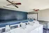 Modern laundry room with multiple washing machines, sleek ceiling fans, and a folding table.