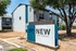 Modern apartment complex exterior with ReNew Scottsdale signage and lush trees.