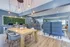 Contemporary apartment showcasing a modern communal area with a wooden dining table, cozy lounge seating, and a sleek kitchen with bar stools.
