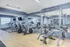Modern fitness center with cardio machines, weightlifting equipment, and mirrored walls.