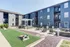 Modern apartment complex featuring a stylish courtyard with seating, fire pit, and outdoor games.