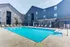 Elegant outdoor pool area surrounded by modern apartment buildings, featuring comfortable lounge chairs.