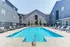 Inviting outdoor pool surrounded by modern apartment buildings with lounge chairs and seating areas.