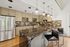 Chic modern kitchen featuring floral backsplash, stainless steel appliances, and marble island with pendant lighting.