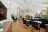 Spacious, modern lounge with high ceilings, elegant lighting, and stylish seating.