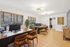 Modern open-plan office with stylish wooden desks, ergonomic chairs, and large windows.