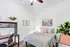 Inviting bedroom with a striped bedspread, decorative plants, and elegant wall art.
