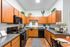 Stylish kitchen with wooden cabinets, black appliances, and greenery accents.