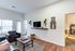 Modern living room featuring sleek furnishings, wall-mounted TV, and elegant decor accents.
