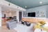 Stylish apartment lounge with modern decor, featuring a TV, sleek seating, and vibrant accents.