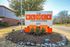 Entrance sign for The Block Townhomes with vibrant orange highlights and a landscaped area.
