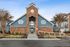 Inviting community center with a brick facade and distinctive blue accents, surrounded by manicured landscaping.