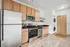 Modern kitchen with stainless steel appliances, light wood cabinetry, and subway tile backsplash.