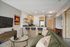 Modern apartment living room with open kitchen, plush seating, and stylish decor.
