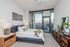 Luxurious bedroom with modern decor, featuring a comfortable bed and large windows overlooking a cityscape.