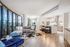 Modern open-concept living room with panoramic city views and sleek kitchen design.