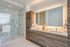 Sleek modern bathroom with a glass shower, double sinks, and ambient lighting.