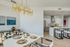 Modern dining area with chic chandelier and adjacent open kitchen.