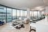 Sleek modern living room with floor-to-ceiling windows offering stunning city views.
